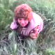 Some kids video record their mother peeing (maybe pooping) while squatting in the grass in this small, low-resolution video clip.